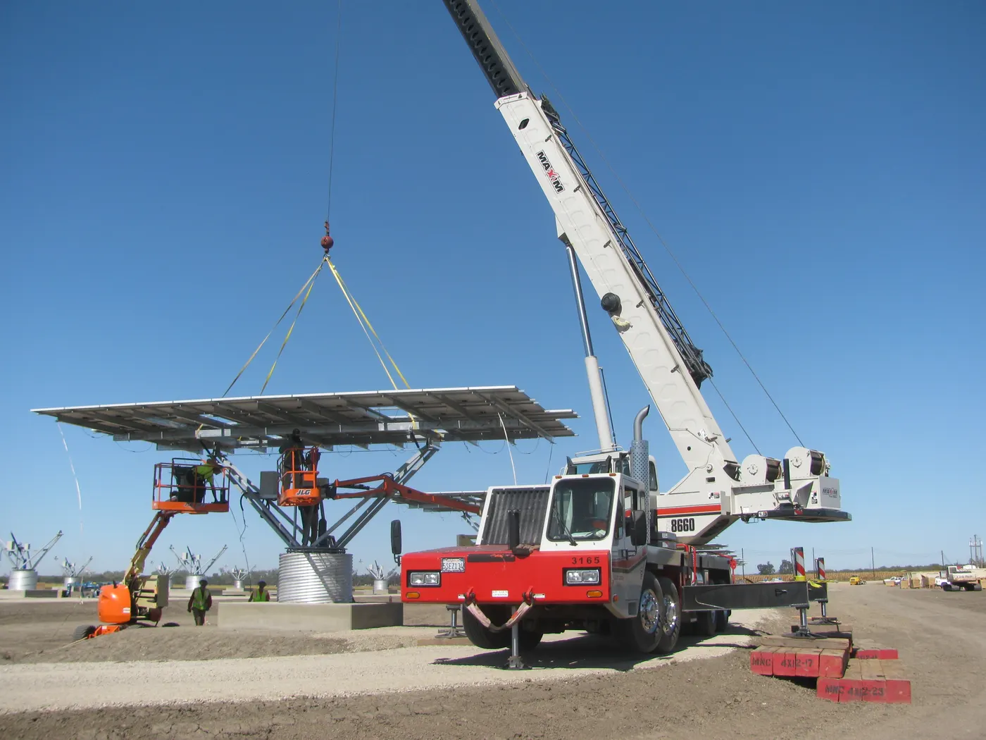 Crane setting a solar tracker during installation